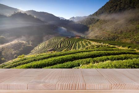 木桌上模糊的茶种植园背景-可用于显示您的产品照片